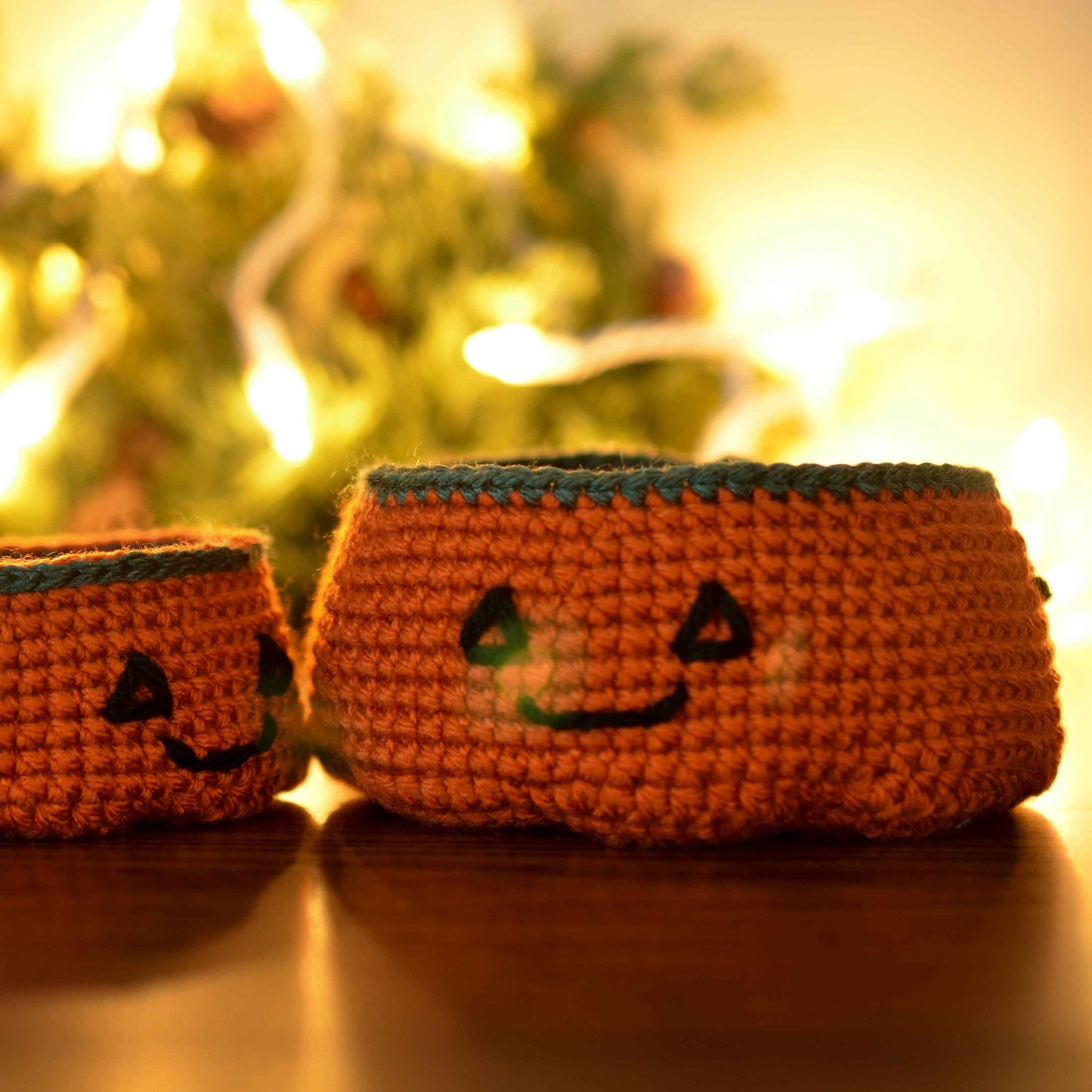 Two pumpkin bowls with Halloween-themed faces, made by following a crochet pattern, are displayed on the desktop.