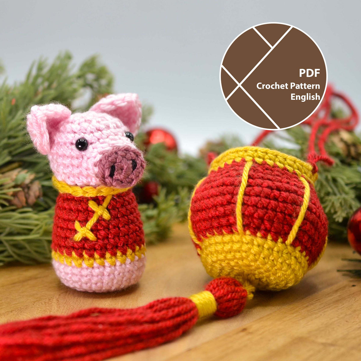 Crocheted pig, wearing lunar-new-year styled costume, standing on a wooden surface. A crocheted lantern is next to the pig.