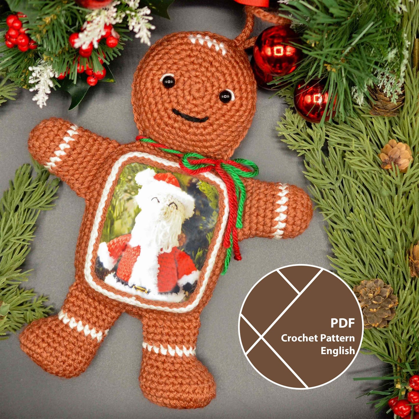 Crocheted gingerbread man ornament with a picture frame in the front. A photo of Santa Claus is displayed inside the frame. The ornament is brown with white trim and has a green and red ribbon around the picture.