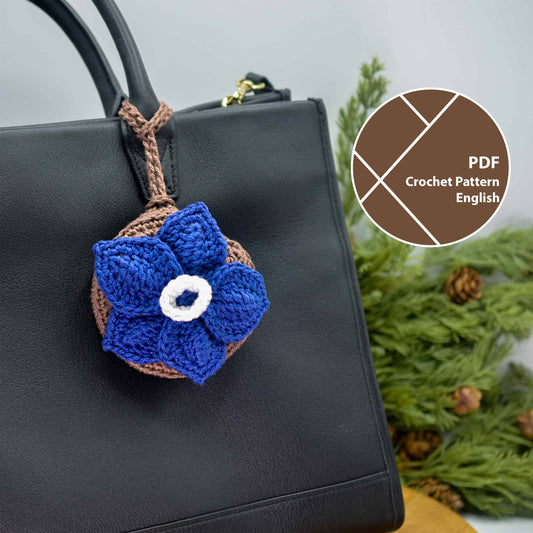 Crocheted blue flower bag charm on a black handbag