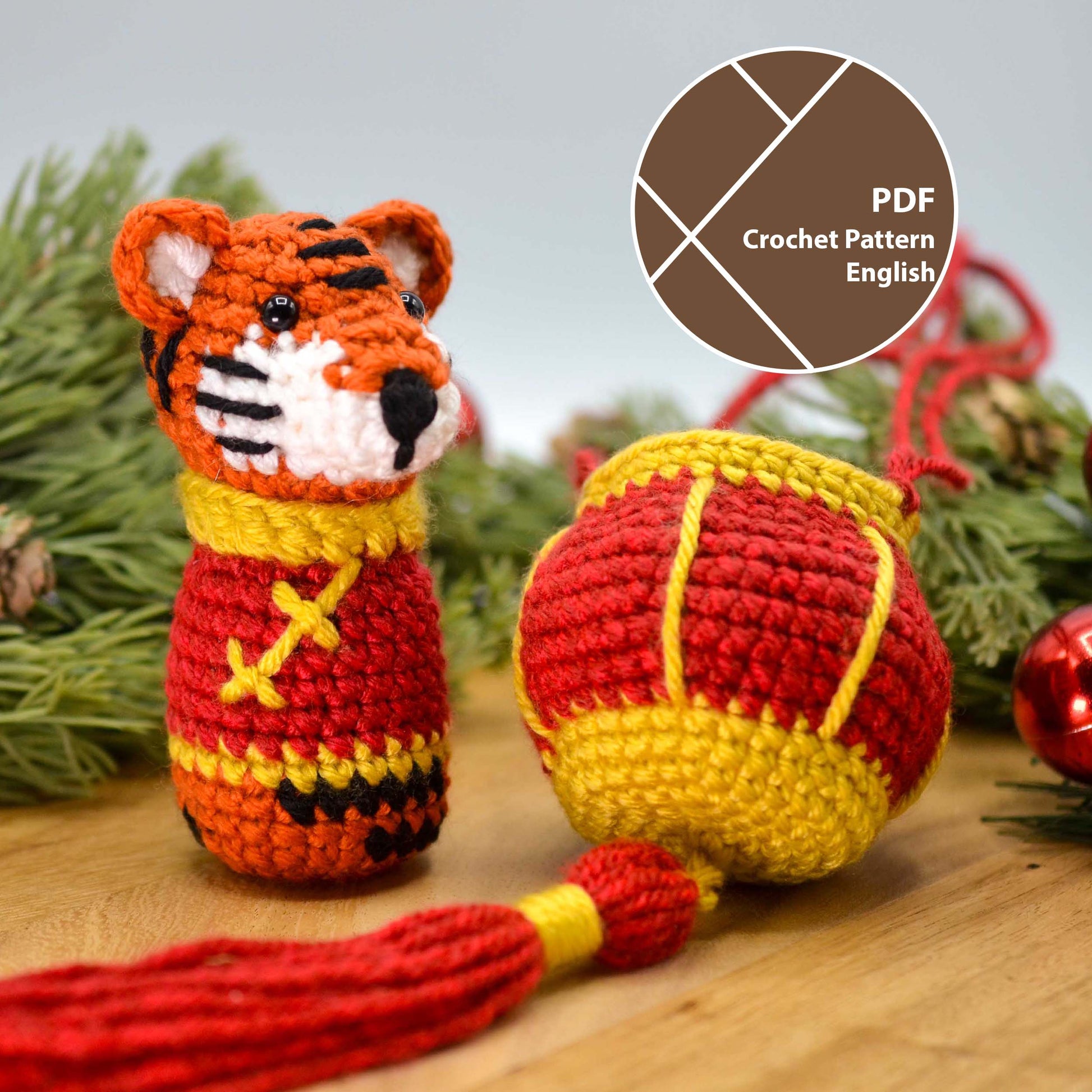 Crocheted lunar new year tiger sitting on a wooden surface. A crocheted red lantern is next to the tiger.