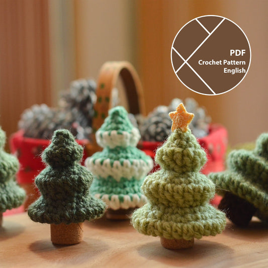 Crochet pattern for mini Christmas tree. Several crocheted pine trees standing on the table, using wine corks as tree trunks. 